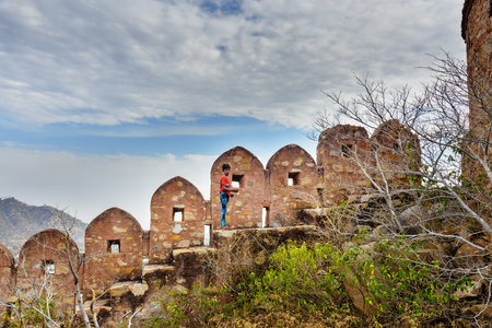 Amber village, India - January 30, 2019: Indian young boy on Ancient long wall with towers around Amber Fort. Jaipur. Rajasthanのeditorial素材
