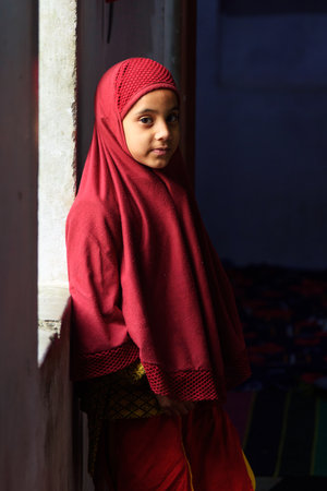 Amber village, India - January 30, 2019: Indian muslum young girl standing at window in Amer. Rajasthanのeditorial素材