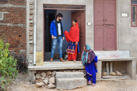 Amber village, India - January 30, 2019: Local indian family grandmother, mother and son at the door...