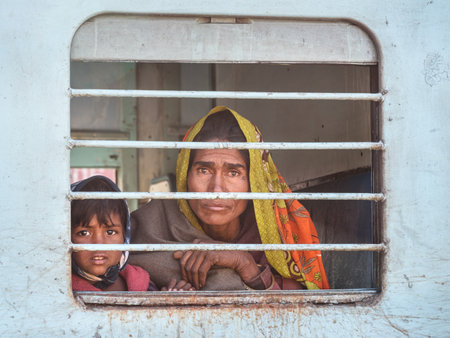 Sambhar, India - February 02, 2019: Indian woman with child is sitting in train, and looking through the train window. Rajasthanのeditorial素材