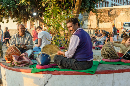 Pushkar, India - February 06, 2019: Indian men playing the drums by Pushkar lake at sunsetのeditorial素材