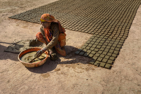 Ajmer, India - February 07, 2019: Indian woman makes manual clay bricksのeditorial素材