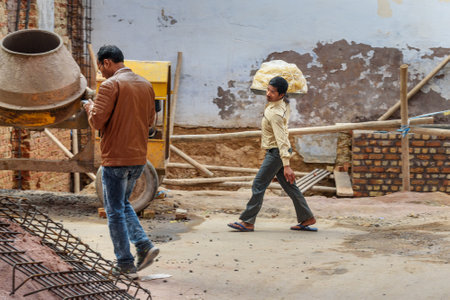 Bikaner, India - February 11, 2019: Indian guy carries sweets on tray for sale on the street in Bekanerのeditorial素材