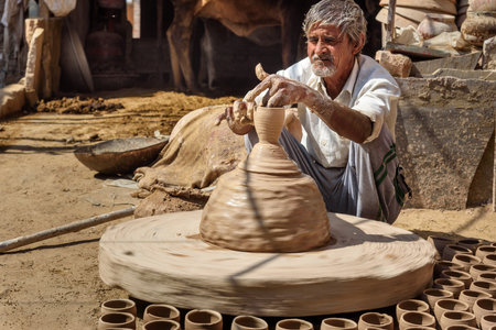 Bikaner, India - February 12, 2019: Indian potter making clay pots on pottery wheel in Bikaner. Rajasthanのeditorial素材