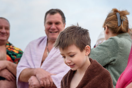 Nizhny Tagil, Russia - January 19, 2019: Boy in towel waiting for bathing into cold water of ice-hole on Epiphany day. Traditional ice swimming in Orthodox church Holy Epiphany Dayのeditorial素材