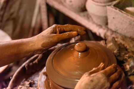 Indian potter making clay pots on pottery wheel in Dharavi Slum at Mumbai. India