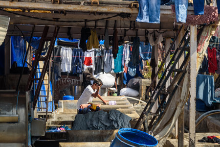 Mumbai, India - February 27, 2019: Indian worker washing clothes in Mahalaxmi Dhobi Ghat is outdoor laundry in Mumbaiのeditorial素材