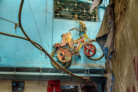 Mumbai, India - February 26, 2019: Bicycles hang on the window in Dharavi Slum at Mumbaiのeditorial素材