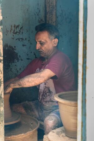 Mumbai, India - February 26, 2019: Indian potter making clay pots on pottery wheel in Dharavi Slum at Mumbaiのeditorial素材