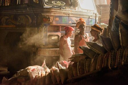 Kolkata, India - March 12, 2019: Indian workers near truck and cargo bagsのeditorial素材