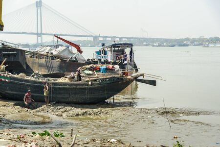 Kolkata, India - March 12, 2019: Indian workers digging Hooghly or Ganga river ground in the boatのeditorial素材