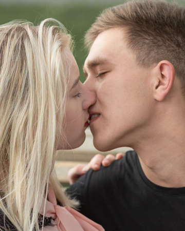 Close-up of young romantic couple is kissing on the streetの写真素材