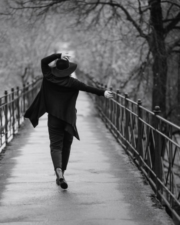 Brunette girl in hat on the bridge in cit in autumn .. Plus size model. Black and whiteの写真素材