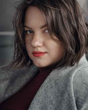 Brunette girl near wall on the street of city. Plus size modelの写真素材