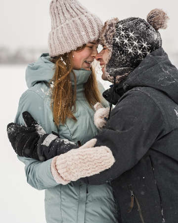 Portrait of smiling couple in love looking at each other. Young happy couple walking in winter day