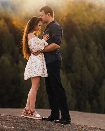 Portrait of young romantic couple kissing in the sun raysの写真素材