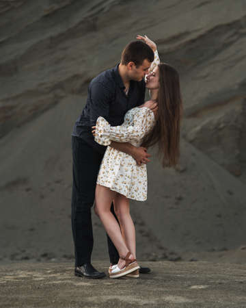 Happy couple dancing outdoors at summertime on gray sand backgroundの写真素材
