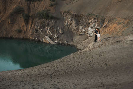 Young man and girl are walking next to the lake in nature. Couple in love spend time forever togetherの写真素材