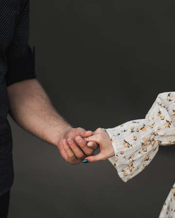 Couple standing side by side and holding outsideの写真素材