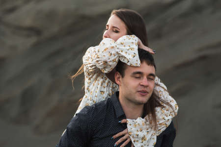 Happy young couple. Man piggybacking his girlfriend outdoor in summerの写真素材