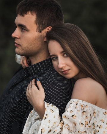 Close up sensual portrait of young couple in love outside. Woman gently hugging her manの写真素材