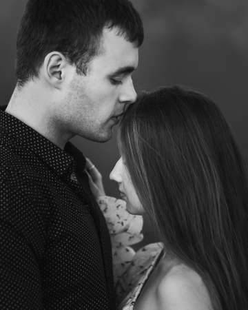 Close up sensual portrait of young kissinf couple in love outside. Black and whiteの写真素材
