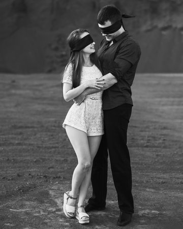Romantic couple blindfolded with black ribbon. Love blind concept. Black and whiteの写真素材