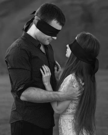 Romantic couple blindfolded with black ribbon. Love blind concept. Black and whiteの写真素材