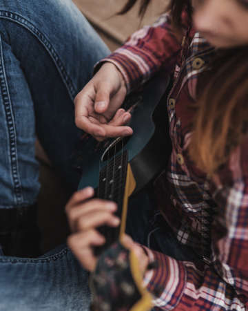 Young woman playing ukulele guitar in autumn forestの写真素材