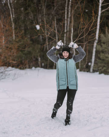 Couple of teenagers building snowman together in winter forestの写真素材