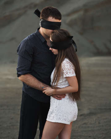 Romantic couple blindfolded with black ribbon outdoors. Love blind conceptの写真素材