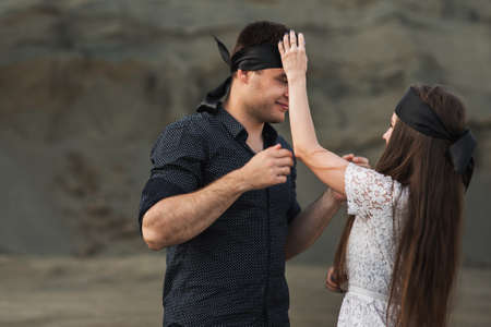 Romantic couple blindfolded with black ribbon outdoors. Love blind conceptの写真素材