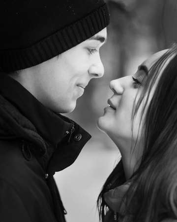 Portrait of couple of teenagers looking at each other in winter forest. Black and whiteの写真素材