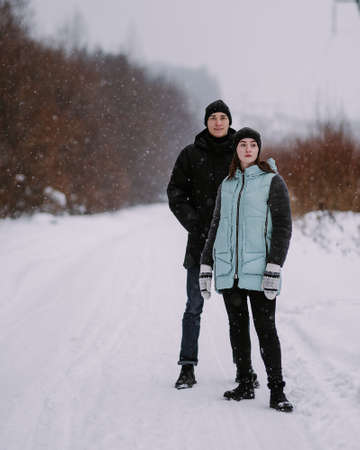 Loving couple of teenagers walking in winter forestの写真素材
