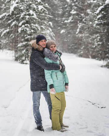 Happy young couple walking in forest on winter dayの写真素材