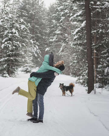 Happy young couple walking in forest on winter dayの写真素材