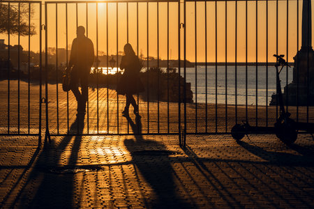 Sevastopol, Crimea - March 14, 2021: Silhouettes of people walking against the sun in embankment in sunsetのeditorial素材