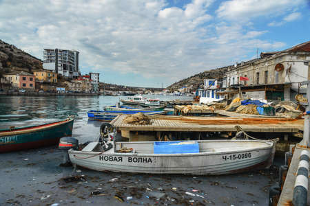 Sevastopol, Crimea - March 15, 2021: View of fishing boats in Balaklava Bay near the pier with nets in springのeditorial素材