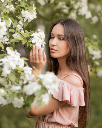 Young woman enjoying in blooming apple spring gardenの写真素材