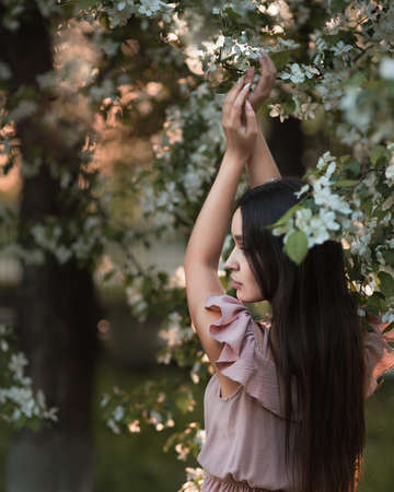 Young woman enjoying in blooming apple spring gardenの写真素材