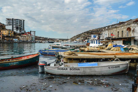 Sevastopol, Crimea - March 15, 2021: View of fishing boats in Balaklava Bay near the pier with nets in springのeditorial素材