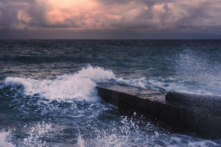 Storm at Black sea at sunset in spring. Sea view with waves during rain and cloudy in Alupka. Crimea. soft focusの写真素材
