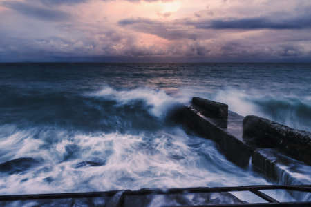 Storm at Black sea at sunset in spring. Sea view with waves during rain and cloudy in Alupka. Crimea. soft focusの写真素材