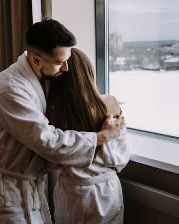 Happy beautiful couple in the hotel on window kiss and hug each otherの写真素材