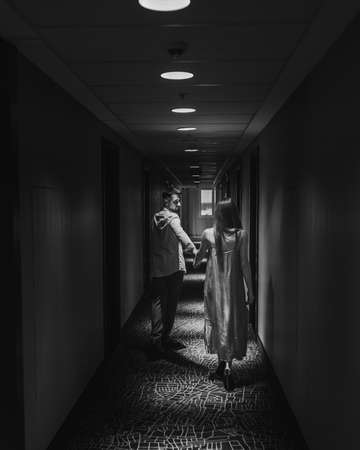 Young couple in love walking along the corridor of the hotel. black and whiteの写真素材