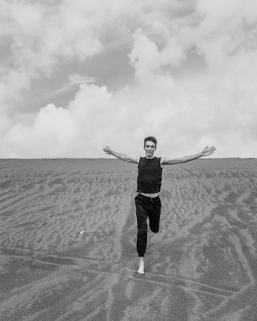 Lone man running on the sand through sandy desert. black and whiteの写真素材