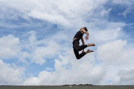Man jumping in the air in blue skyの写真素材