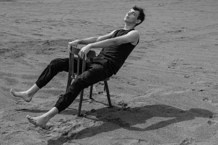 Lone Man sitting on chair in desert. black and whiteの写真素材