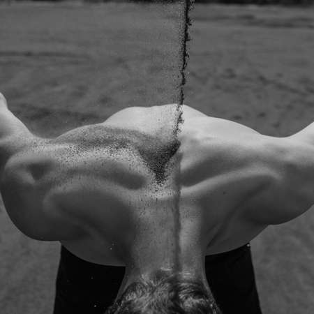 sand falls on the man's back. black and whiteの写真素材