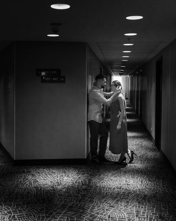Young couple in love standing and kissing in the corridor of the hotel. black and whiteの写真素材